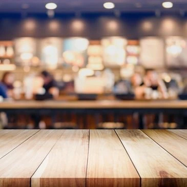 Cozy café setting with a wooden table, reflecting a workspace for web design for small businesses. Warm lighting and creative ambiance.