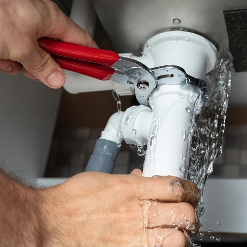 Professional plumbing repair under a sink—small businesses offering home services can benefit from affordable web design.