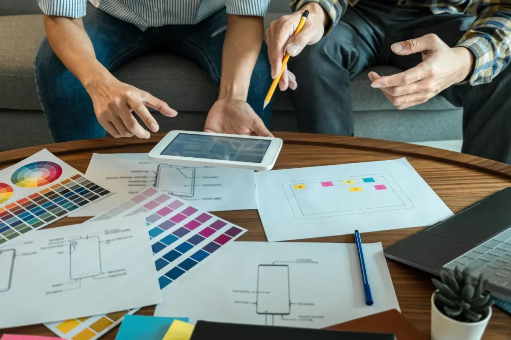 Creative planning session for a website for small businesses, featuring mobile wireframes, color swatches, and tablet interface.